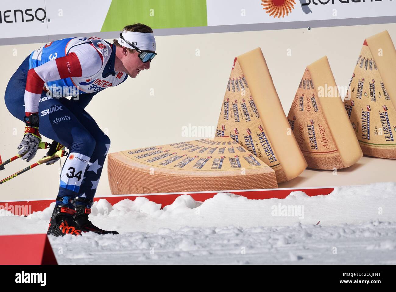 KYLE Bratrud, membro DELLA squadra di sci DEGLI STATI UNITI, ha superato un cartello per lo sponsor FIS, il formaggio Gruyere, 2019 FIS World Championships, Seefeld, Austria. Foto Stock