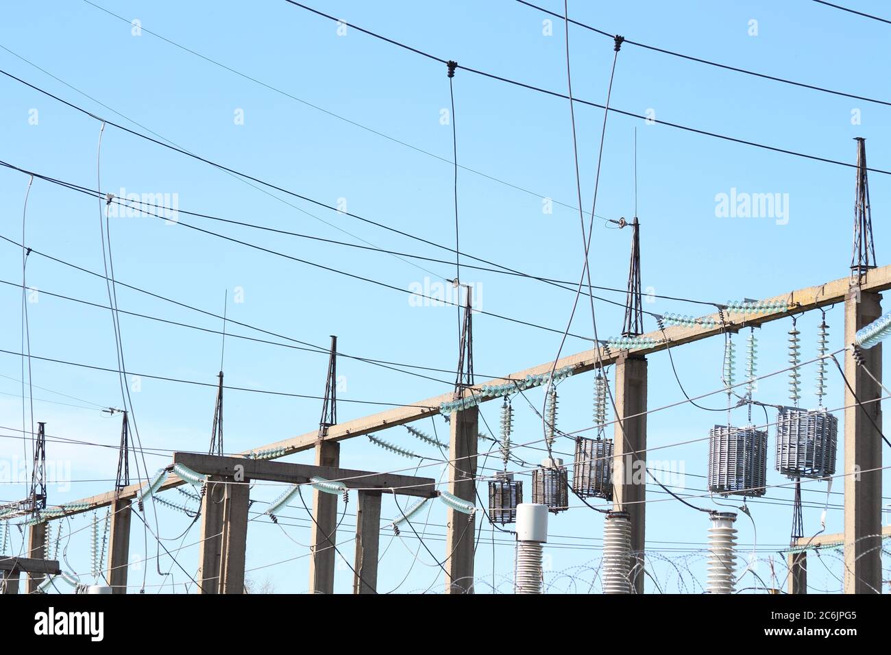 i trasformatori elettrici sono sospesi su pali in cemento contro il cielo. Foto Stock