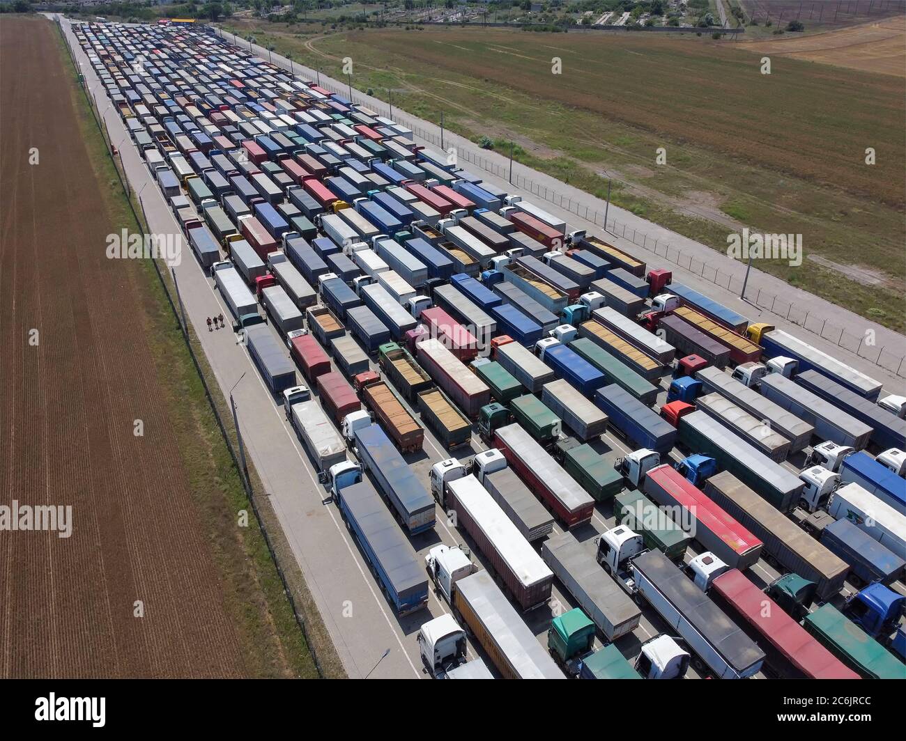 Trasporto del carico e logistica, molti camion nell'area portuale stanno aspettando il loro turno di scarico. Una lunga linea di carrelli con grano. Foto Stock