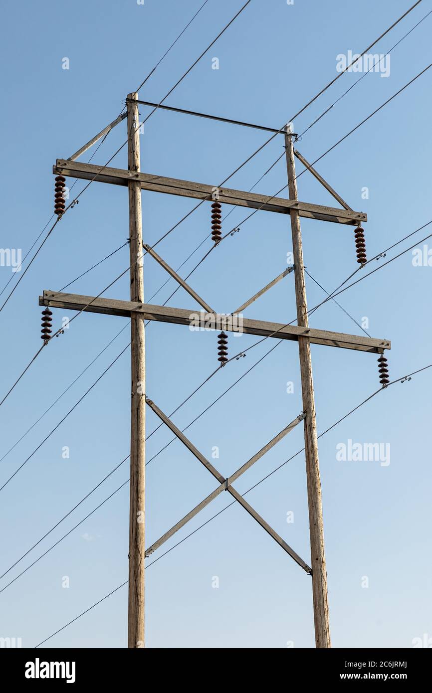 Palo elettrico in legno con cielo blu sullo sfondo Foto Stock