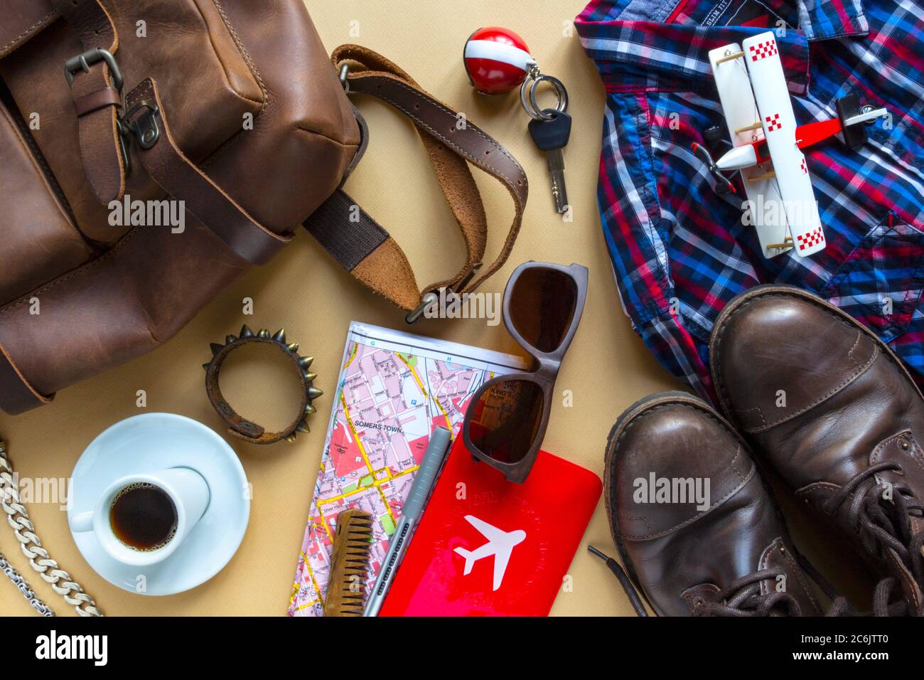 Accessori da uomo, dispositivi, caffè, aereo, chiavi, mappa, scarpe in  pelle e zaino su sfondo cammello. Concetto di cancellazione di viaggio e  vacanza Foto stock - Alamy