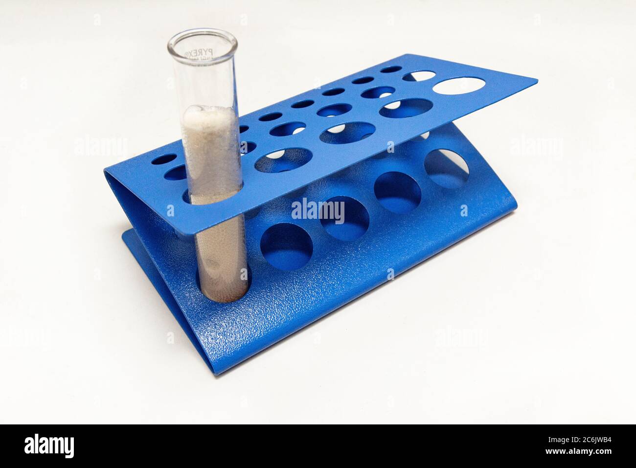 Reazione a doppio spostamento tra bicarbonato di sodio e aceto in una provetta posta in un rack per provette. Foto Stock