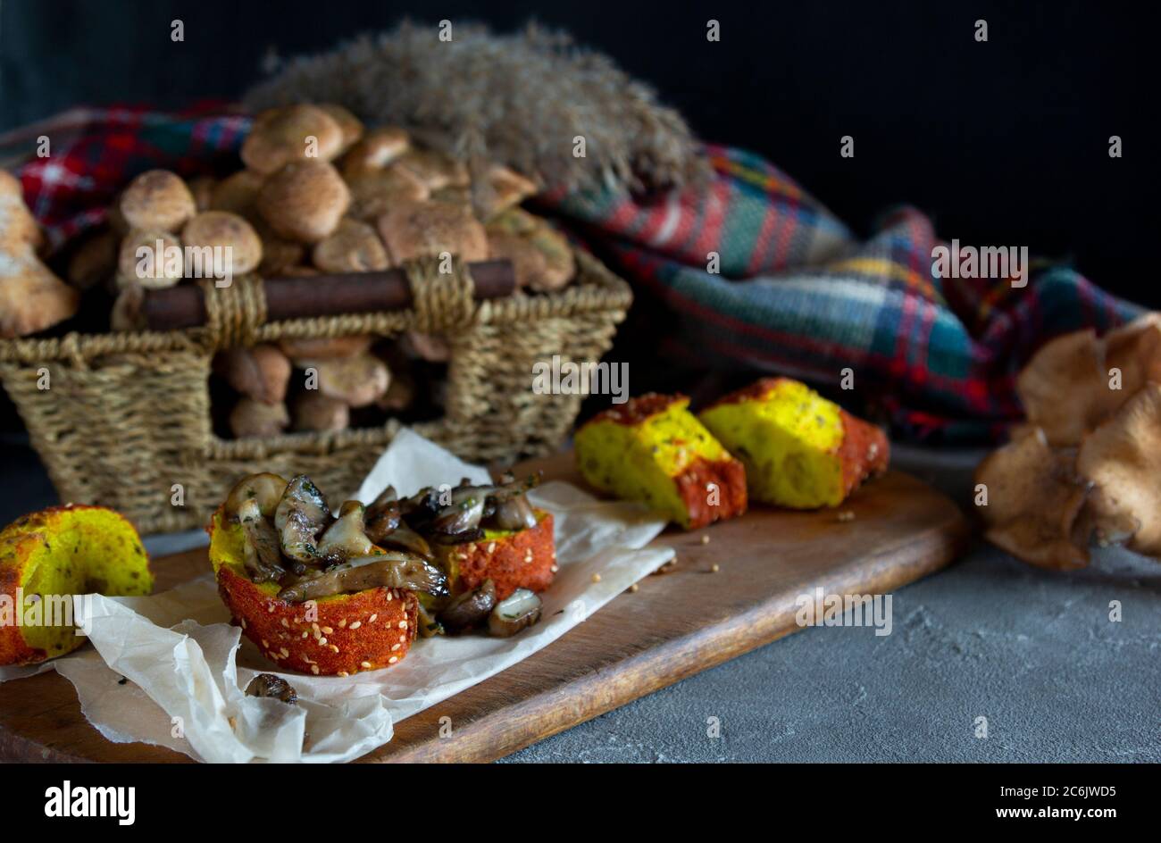 Funghi di bosco agarici di miele (Armillaria mellea). Composizione autunno ancora vita. Funghi fritti dorati su pane su tavola scura. Orizzontale Foto Stock
