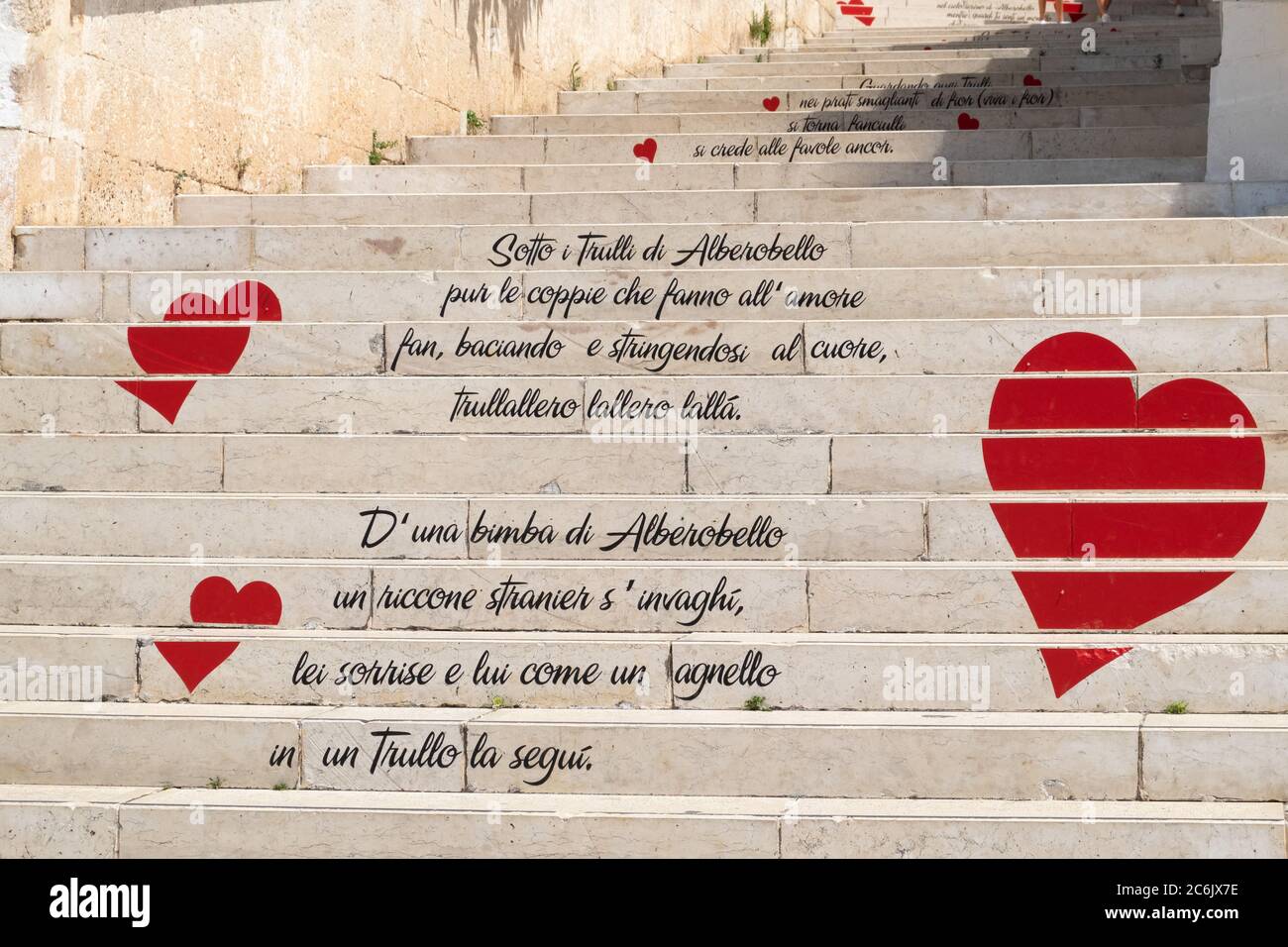 Puglia - Alberobello, vista sulla lunga scalinata in marmo con frasi  romantiche scritte sui gradini e sui cuori rossi Foto stock - Alamy