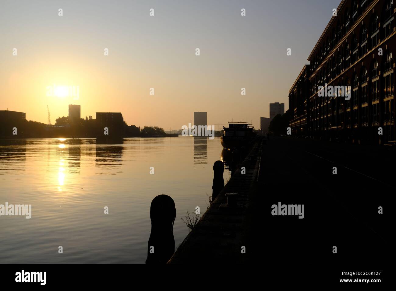 Silhouette di edifici moderni sul fiume IJ in estate poco prima del tramonto ad Amsterdam, Paesi Bassi Foto Stock