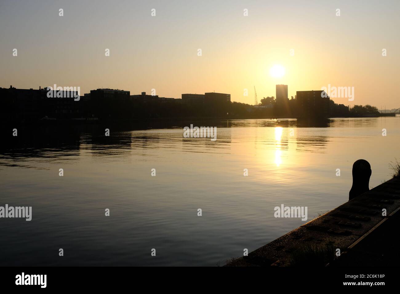 Silhouette di edifici moderni sul fiume IJ in estate poco prima del tramonto ad Amsterdam, Paesi Bassi Foto Stock