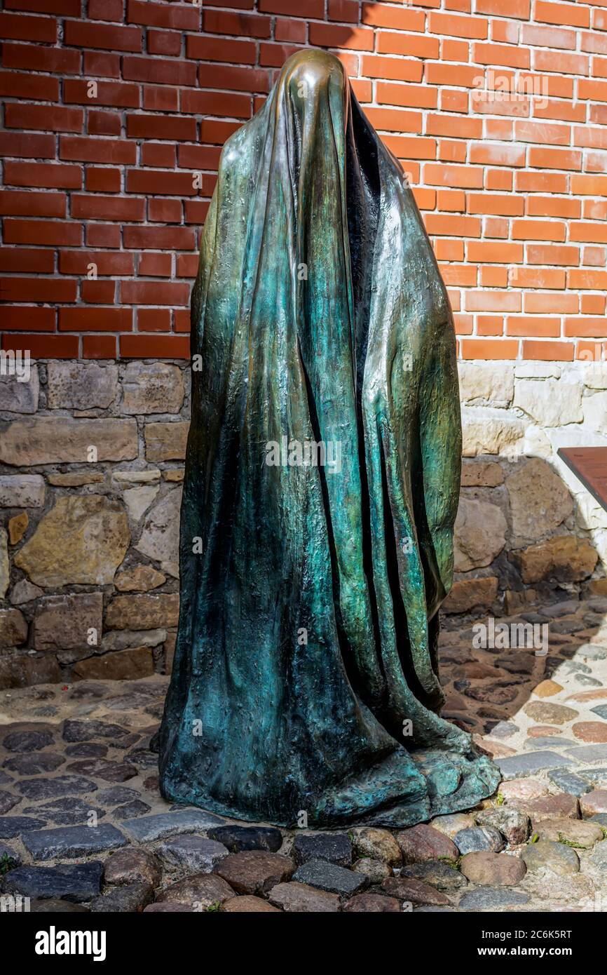 La scultura in bronzo fantasma nella città vecchia vicino al muro di difesa medievale. Foto Stock