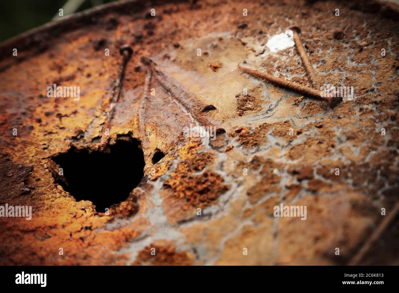 Vecchi chiodi arrugginiti nella superficie del tamburo dell'olio. Foto Stock