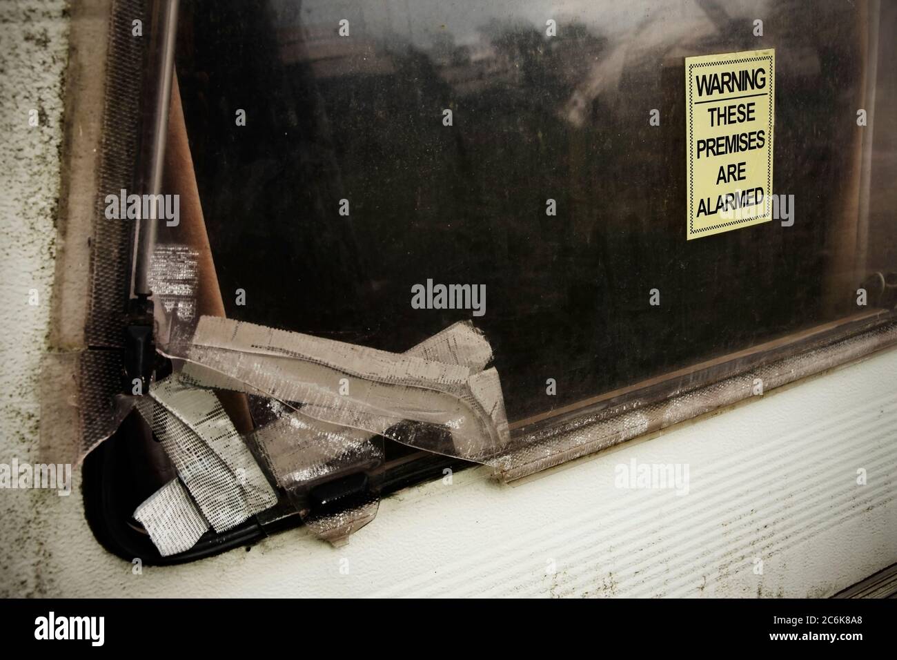 Adesivo di avvertenza sul vecchio finestrino della carovana sporco rotto. Foto Stock