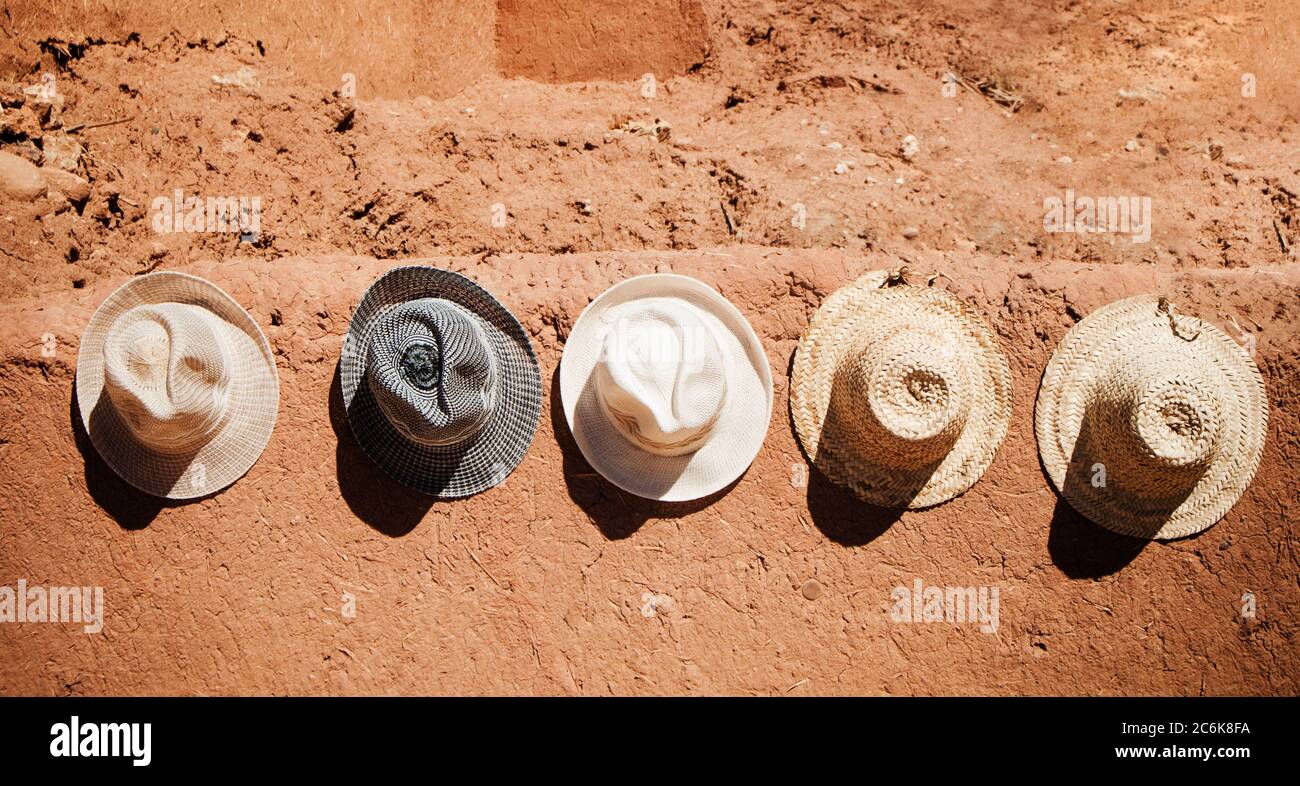 Cappelli appesi a un muro di pietra villaggio Merzouga, Marocco Foto Stock