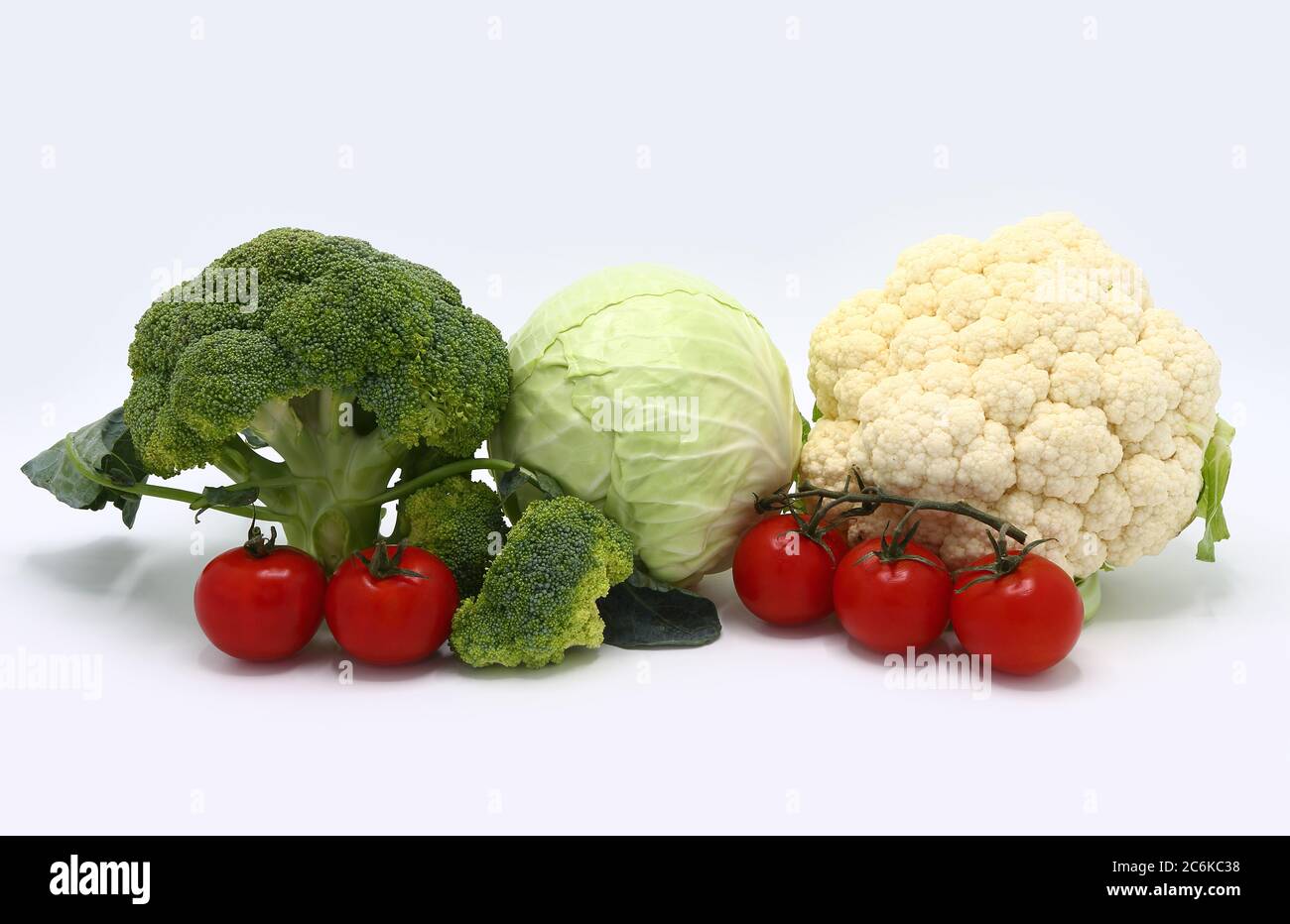 Testa di cavolo, infiorescenze di broccoli e cavolfiore e pomodori maturi rossi su sfondo chiaro. Prodotto naturale. Tonalità naturale. Primo piano. Foto Stock