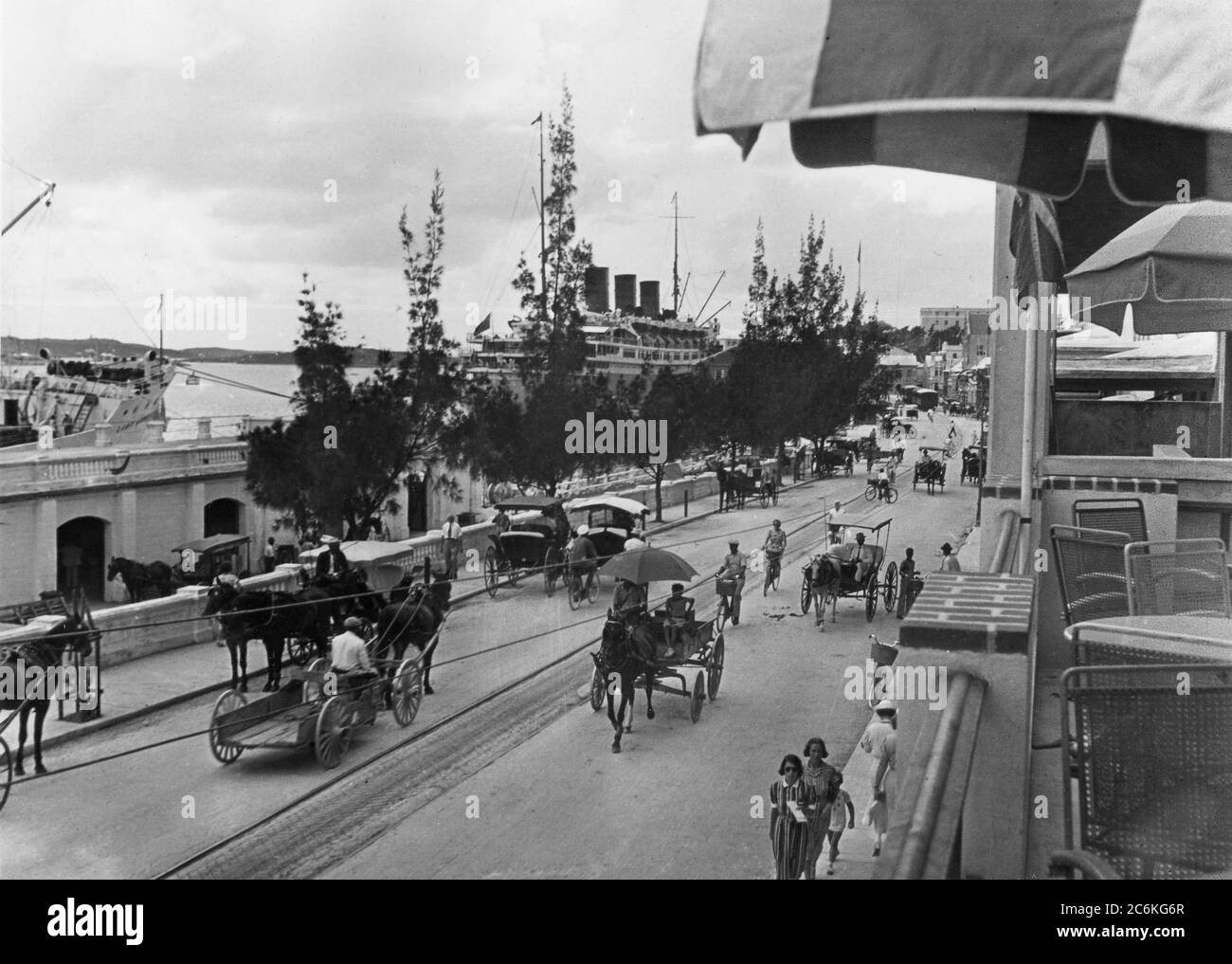 Bermuda. Inizio 1930s. Una strada trafficata. Front Street, Hamilton, Bermuda. Le navi sono ormeggiate sullo sfondo. Foto Stock