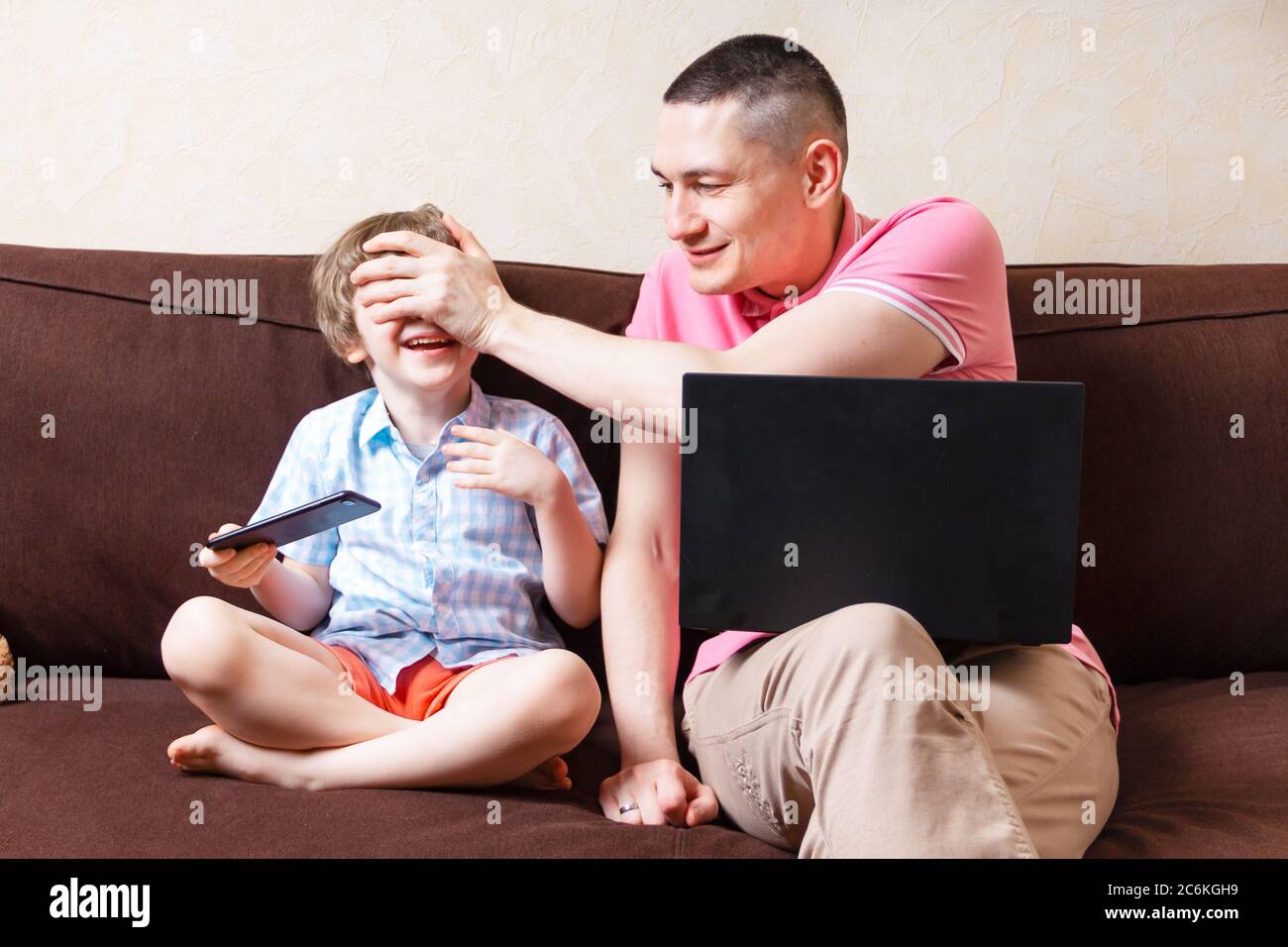 Divertente giovane padre sedersi sul computer portatile ingannare intorno  con cute bambino figlio divertirsi insieme, sorridendo papà e bambino  piccolo goda stare a casa riposo su Foto stock - Alamy