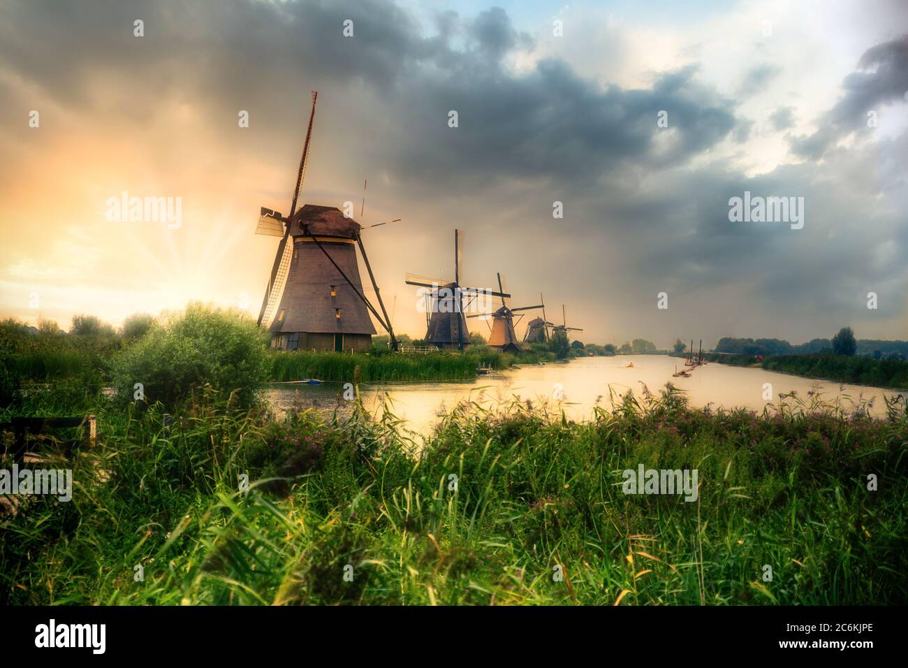 Splendidi mulini a vento olandesi e paesaggio sotto il suggestivo cielo del tramonto Foto Stock