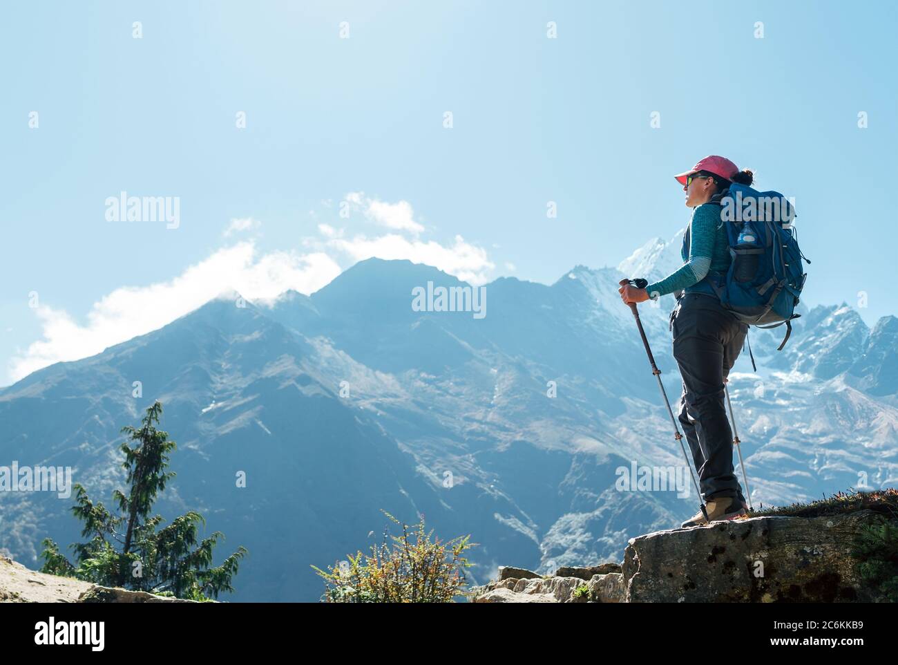 Giovane escursionista zaino in spalla femmina utilizzando pali da trekking  godendo di vista montagna durante l'alta altitudine acclimatazione  passeggiata. Percorso di trekking Everest base Camp Foto stock - Alamy