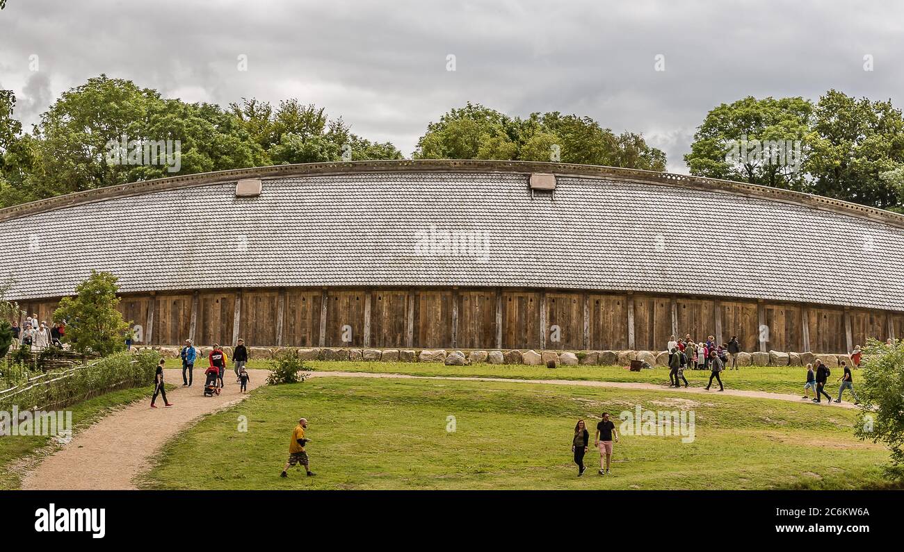 Persone di fronte alla Sala del Re una casa medievale. Ricostruzione di una sala vichinga del 700 a Lejre, Danimarca, 9 luglio 2020 Foto Stock