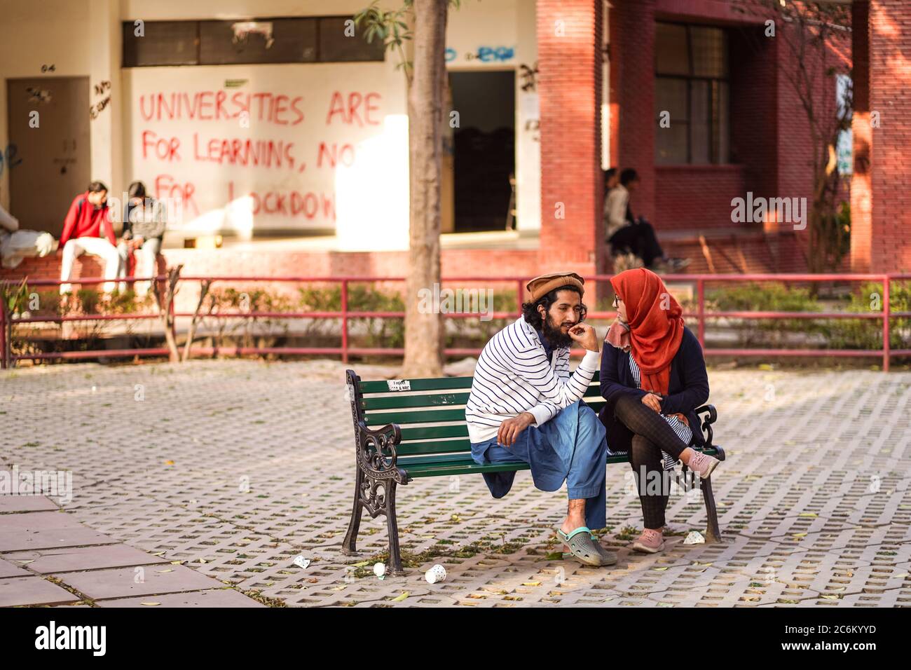 Nuova Delhi / India - 16 febbraio 2020: Giovani studenti musulmani seduti all'interno del campus universitario della Jamia Millia Islamia porta d'ingresso Foto Stock