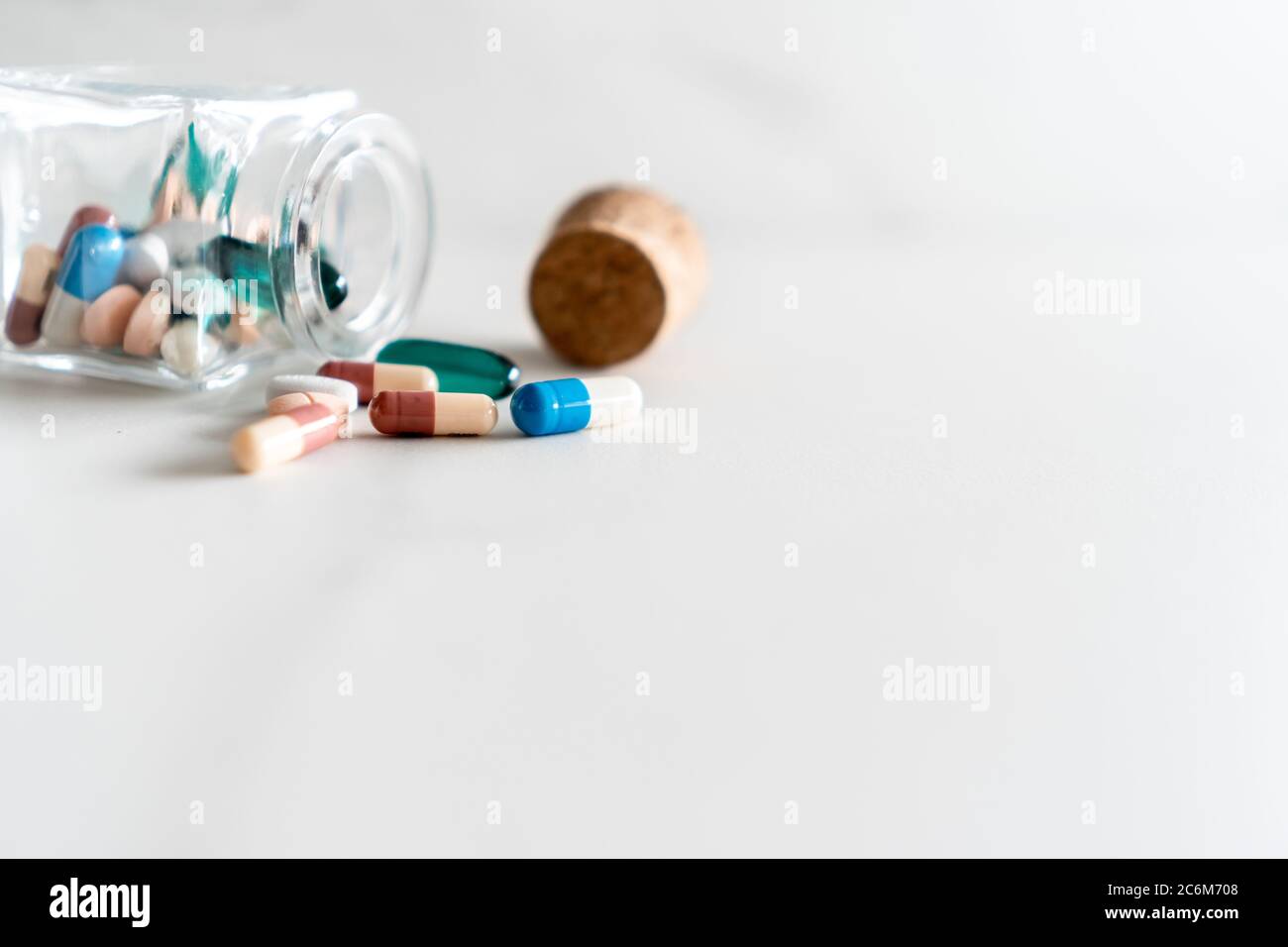 Vista dall'alto delle compresse di medicina versare da pillole flacone di marmo texture sfondo bianco. Concetto di tendenza di stile di vita medico di assistenza sanitaria. Foto Stock