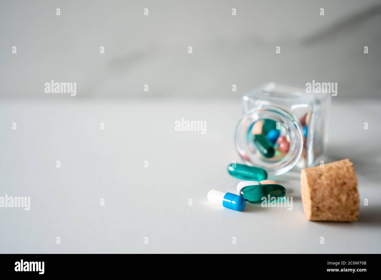 Vista dall'alto delle compresse di medicina versare da pillole flacone di marmo texture sfondo bianco. Concetto di tendenza di stile di vita medico di assistenza sanitaria. Foto Stock