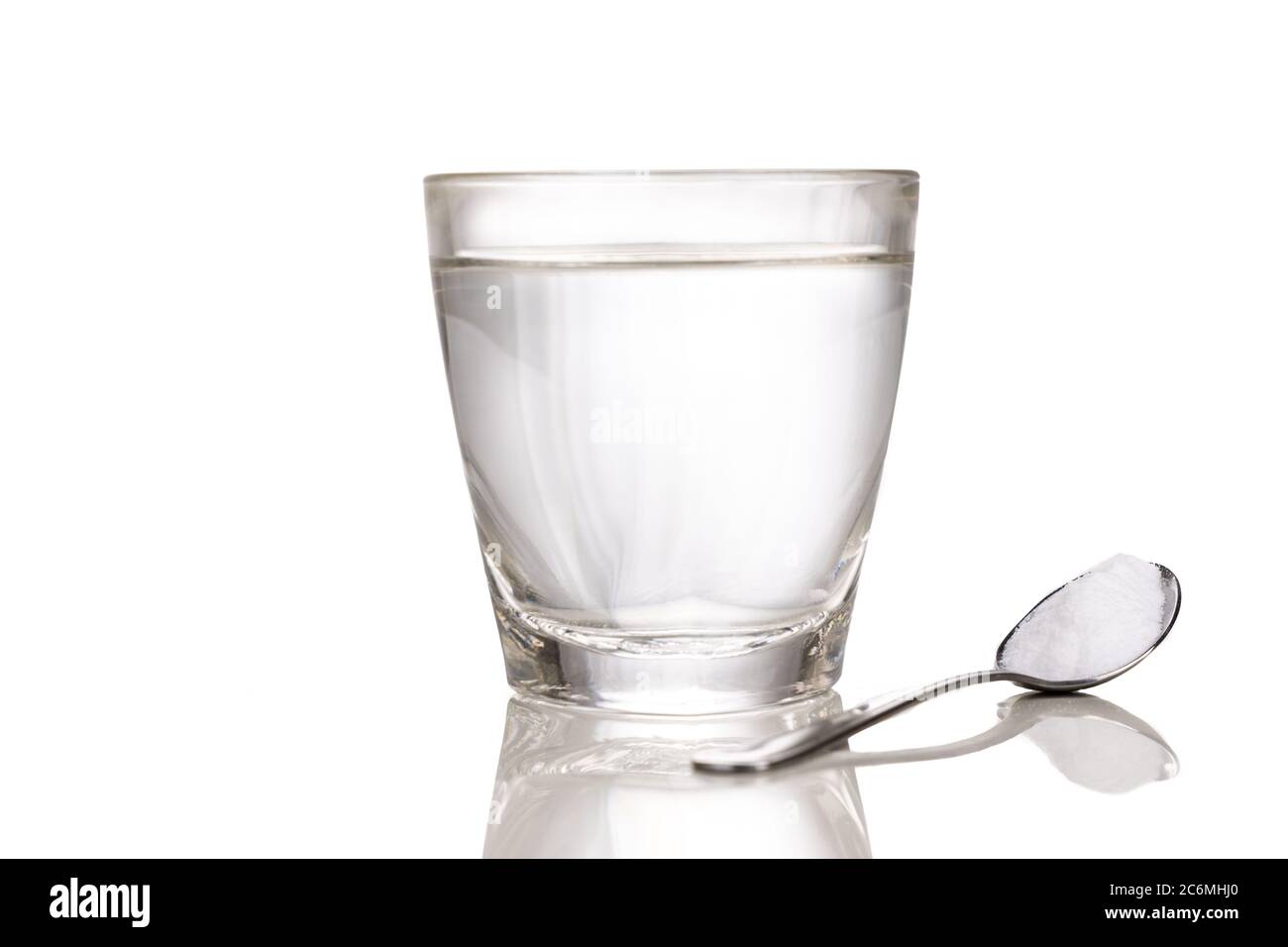 Sale di reidratazione orale o oralmente con un bicchiere d'acqua e un cucchiaio con fondo bianco Foto Stock