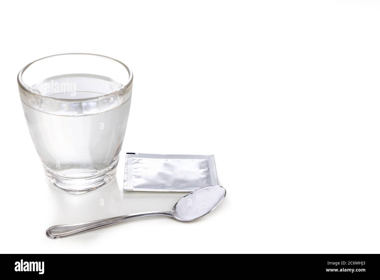Sale di reidratazione orale o orale con un bicchiere d'acqua, bustina e cucchiaio con fondo bianco Foto Stock