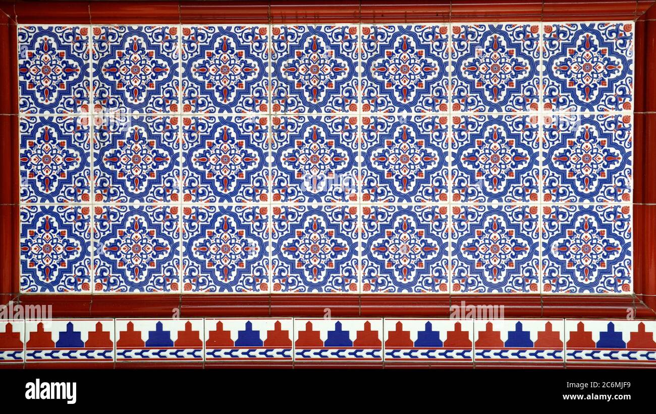 Un mosaico di piastrelle in ceramica con motivi floreali blu e rosso, tipicamente trovato sulla facciata delle tradizionali botteghe cinesi Peranakan. Foto Stock