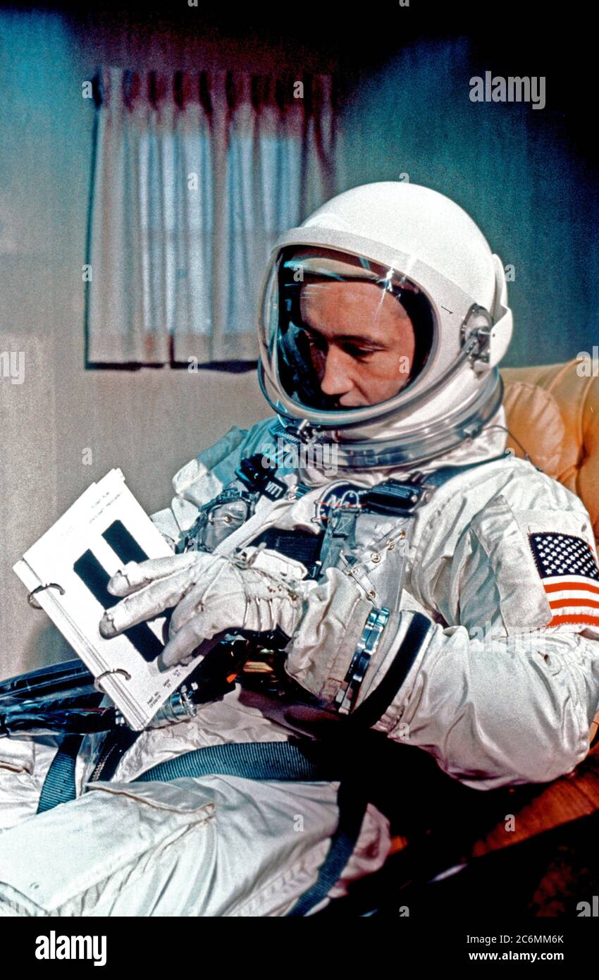 (3 giugno 1965) --- astronauta James McDivitt A., Gemini-4 il comando pilota, è mostrata in modo completo tuta in tuta rimorchio prima del lancio. Egli sta esaminando un equipaggio procedure flip libro. Foto Stock