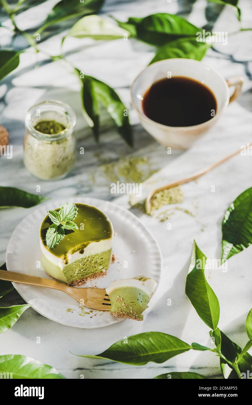 Cheesecake matcha verde e caffè nero in tazza, fuoco selettivo Foto Stock
