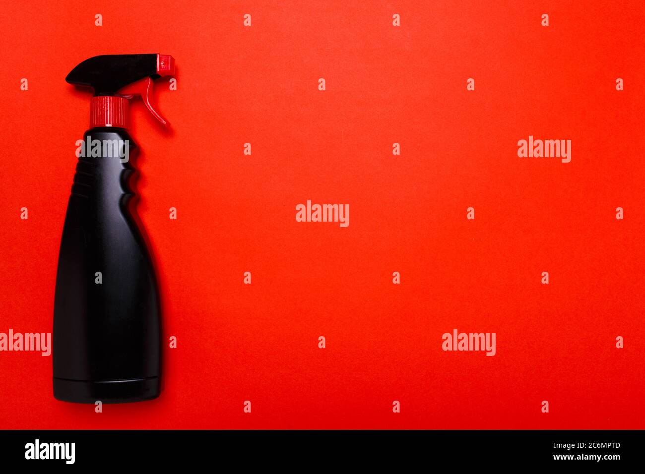 detergente spray nero per la pulizia del vetro su fondo rosso. copyspace Foto Stock