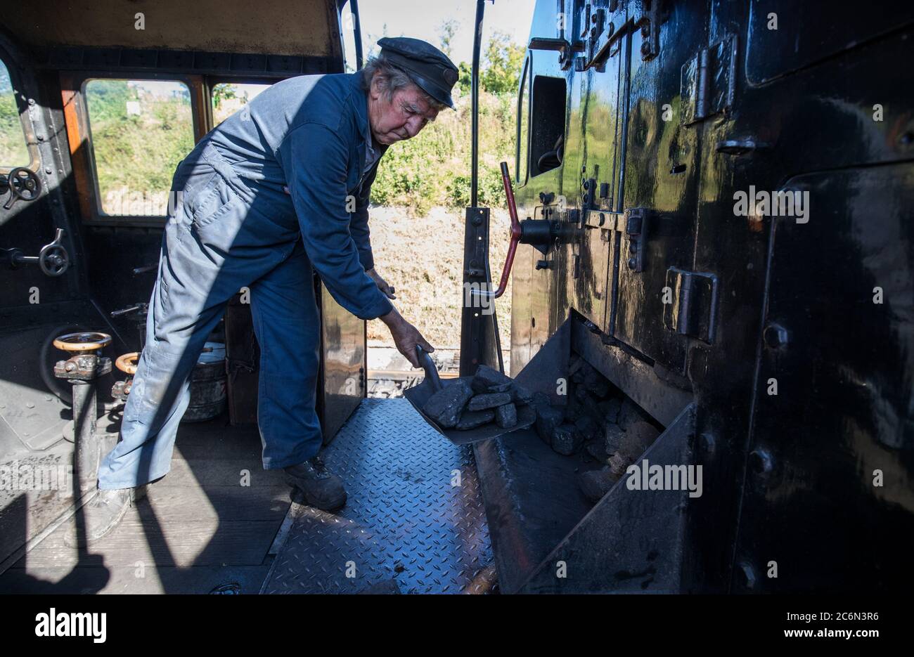 Il carbone viene smontato nel fuoco sulla locomotiva a vapore British Railways Standard Class 4MT 76017 nel cantiere della stazione di Rotley, mentre la Mid Hants Railway, nota anche come linea di Watercress, si prepara a riaprire al pubblico in seguito all'allentamento delle restrizioni di blocco in Inghilterra. Foto Stock
