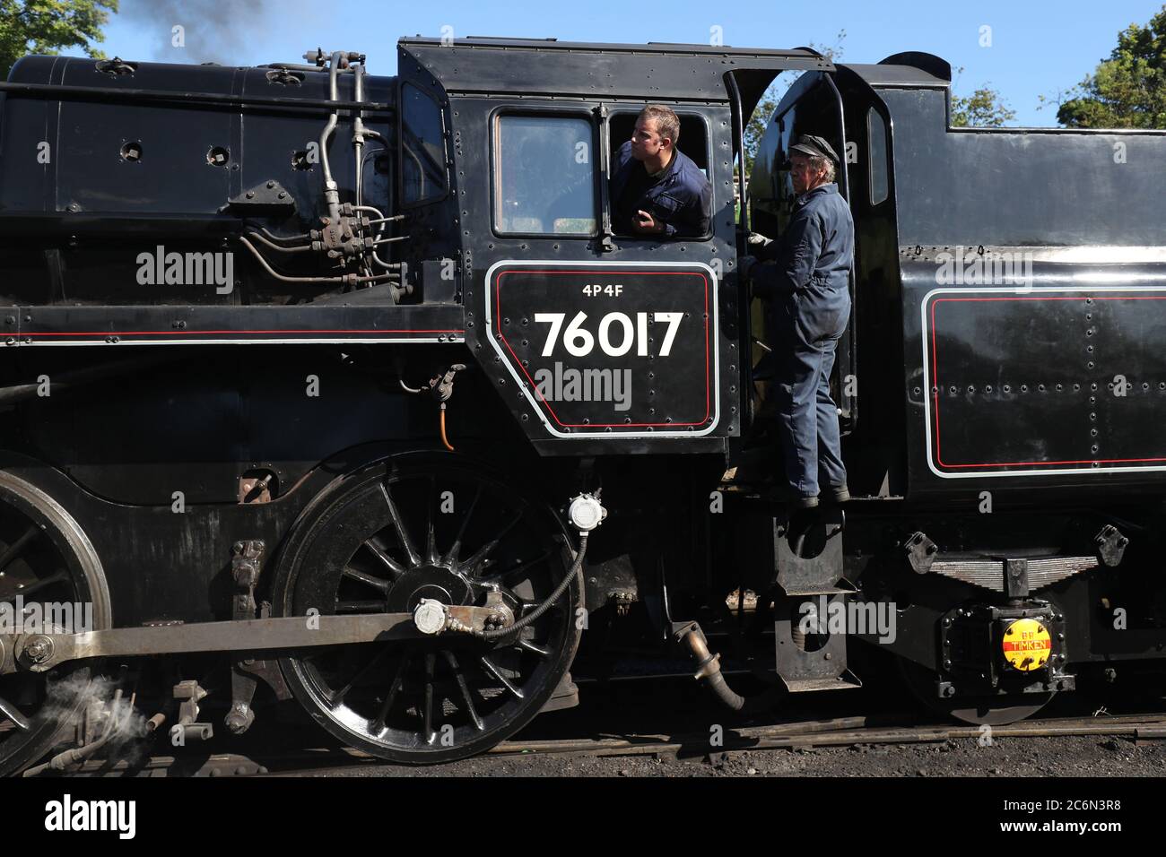 Un autista e vigili del fuoco guardano fuori dalla British Railways Standard Class 4MT locomotiva a vapore 76017, mentre si è spostato in posizione alla stazione di Rotley, come la Mid Hants Railway, anche conosciuta come la linea di Watercress, si prepara a riaprire al pubblico. Foto Stock