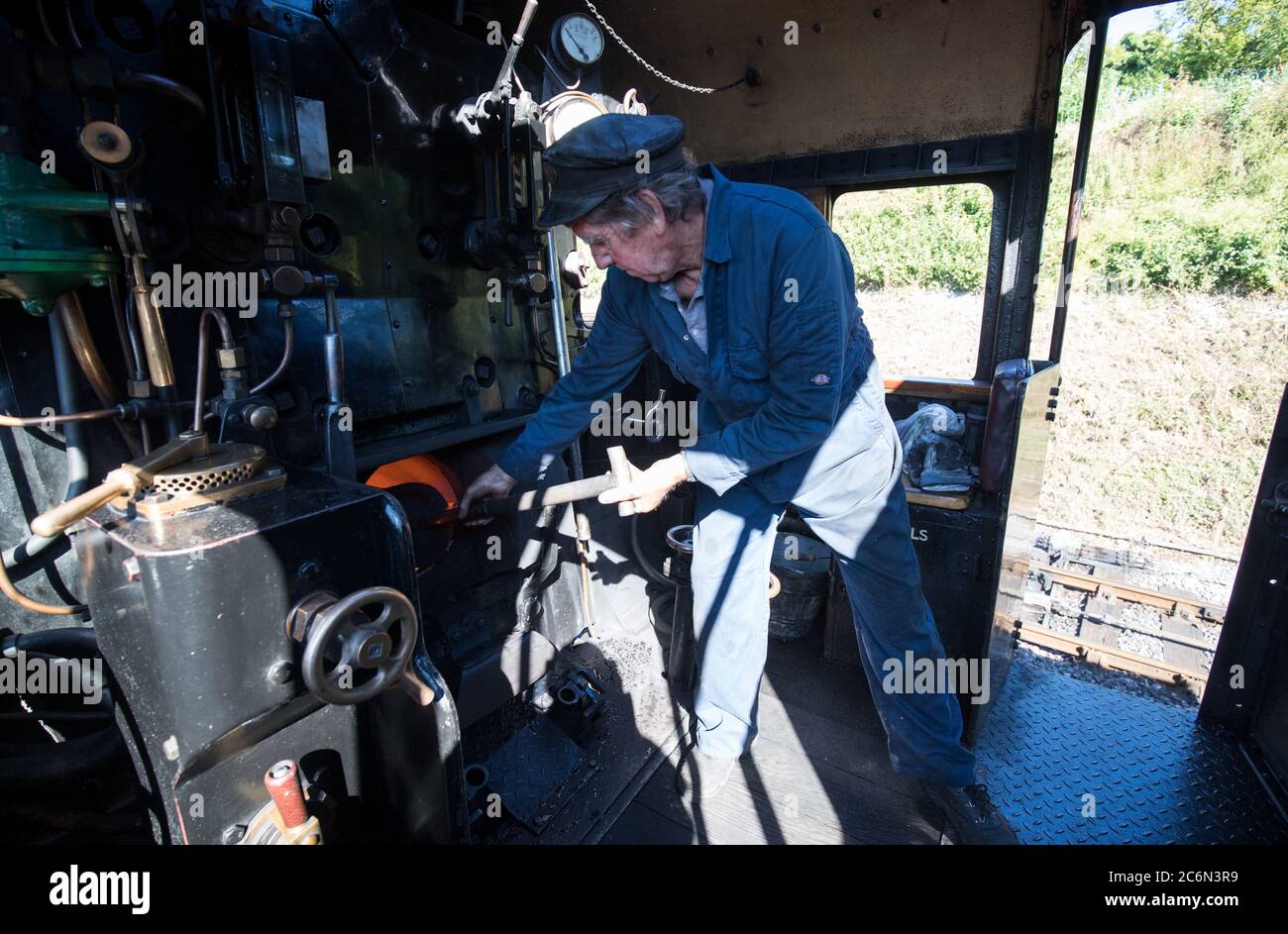 Il carbone viene smontato nel fuoco sulla locomotiva a vapore British Railways Standard Class 4MT 76017 nel cantiere della stazione di Rotley, mentre la Mid Hants Railway, nota anche come linea di Watercress, si prepara a riaprire al pubblico in seguito all'allentamento delle restrizioni di blocco in Inghilterra. Foto Stock