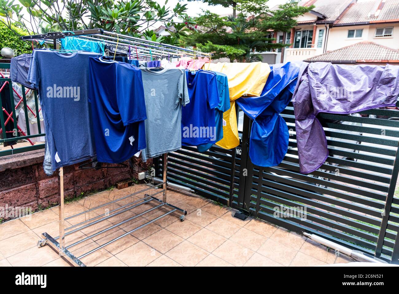 Tessuto di lavanderia che viene asciugato sotto il sole caldo luminoso in composto domestico dopo il lavaggio in Malesia Foto Stock