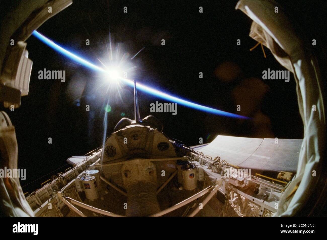 (17 aprile - 3 maggio 1998) --- UN obiettivo speciale su una telecamera da 35 mm dà un effetto fish-eye a questa "vista notturna" fuori dalla finestra dalla cabina della Space Shuttle Columbia. Il modulo scientifico Spacelab, che ospita 16 giorni di ricerche di Neurolab, è al centro del quadro. Il tunnel che conduce dalla cabina al modulo scientifico nel vano di carico si trova in basso al centro. Il sole può essere visto scoppiare sopra l'orizzonte della Terra e lo strato blu di aria bagliore. Foto Stock