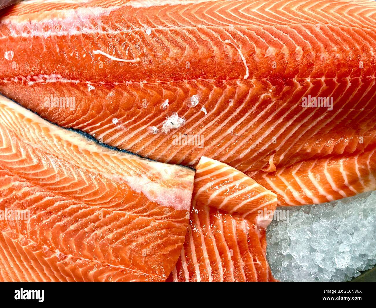 Filetti di salmone appena tagliati su ghiaccio in un mercato del pesce Foto Stock