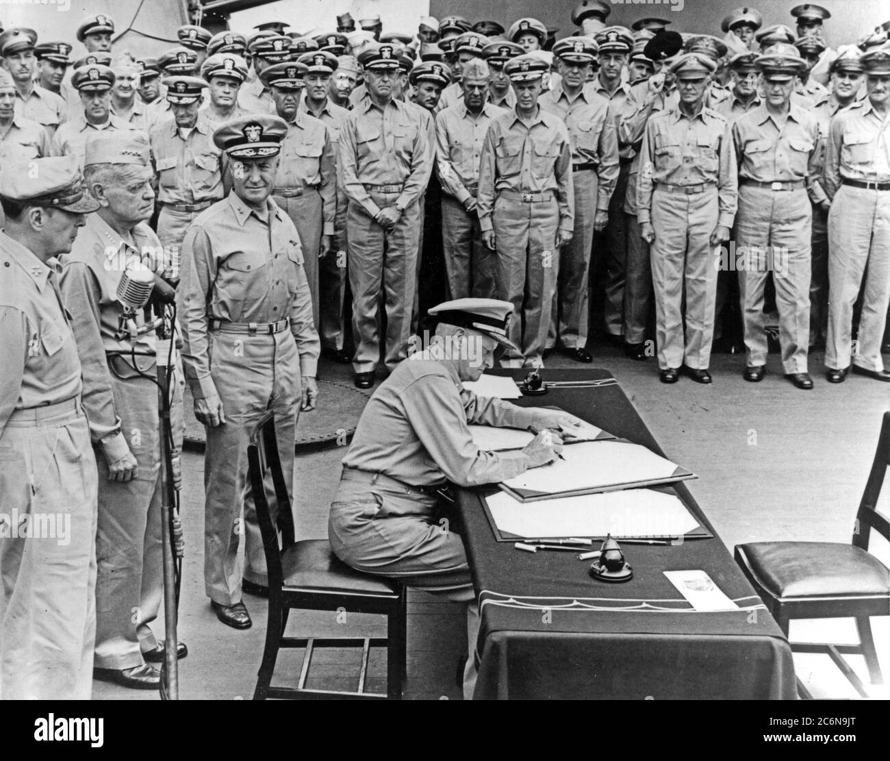 Consegna del Giappone, Baia di Tokyo, 2 settembre 1945. ADM flotta. Chester W. Nimitz, Marina degli Stati Uniti, firma lo strumento di resa come rappresentante degli Stati Uniti, a bordo della USS Missouri (BB-63), 2 settembre 1945. Dietro di lui si trovano (da sinistra a destra): Generale dell'esercito Gen. Douglas MacArthur; ADM. William F. Halsey, U.S. Navy e posteriore ADM. Forrest Sherman, Marina degli Stati Uniti. (STATI UNITI Foto blu, Foto n.: 80-G-701293) Foto Stock