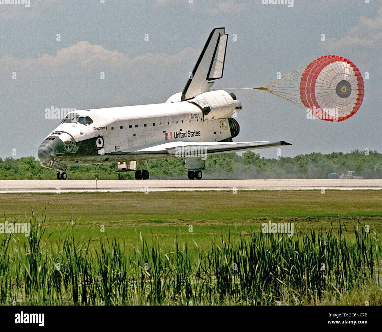 Con il suo scivolo di trascinamento attivato, l'orbiter Discovery tocca la pista 15 del servizio di atterraggio a navetta di KSC per completare la missione STS-91. Il 00 giugno 1998, il principale ingranaggio di touchdown è stato alle 14:18:12 p.m. EDT, atterrando sull'orbita 155 della missione. Le ruote si sono fermate alle 14:01:22 EDT, per un tempo totale trascorso dalla missione di 9 giorni, 19 ore, 55 minuti e 1 secondo. Foto Stock