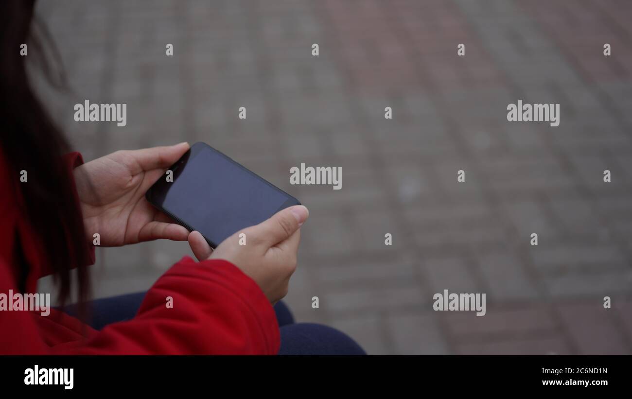 Le mani delle donne che tengono il telefono da vicino. Spazio per il testo. Foto Stock