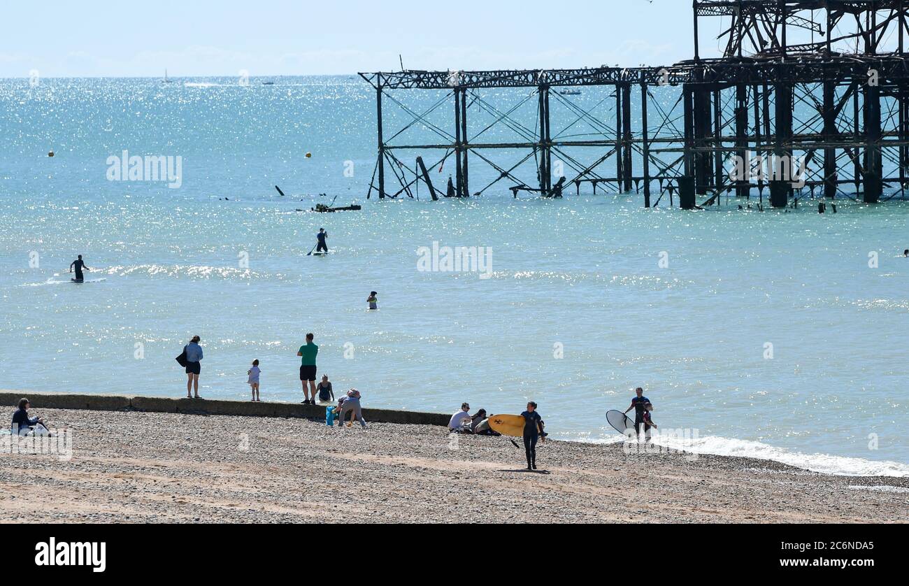 Brighton UK 11 luglio 2020 - i visitatori si recano alla spiaggia di Brighton, mentre si fanno il massimo di una bella giornata di sole sulla costa meridionale : Credit Simon Dack / Alamy Live News Foto Stock