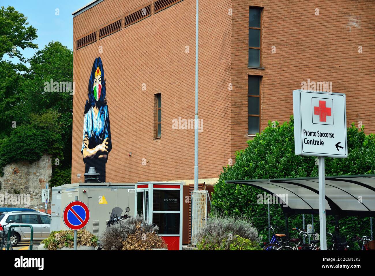 Padova, Italia. L'artista di strada Alessio-B dipinge un ritratto di Wonder  Woman vestito da medico con un camice bianco, maschera tricolore chirurgica  e lo stetoscopio su un muro dell'ospedale di Padova, in