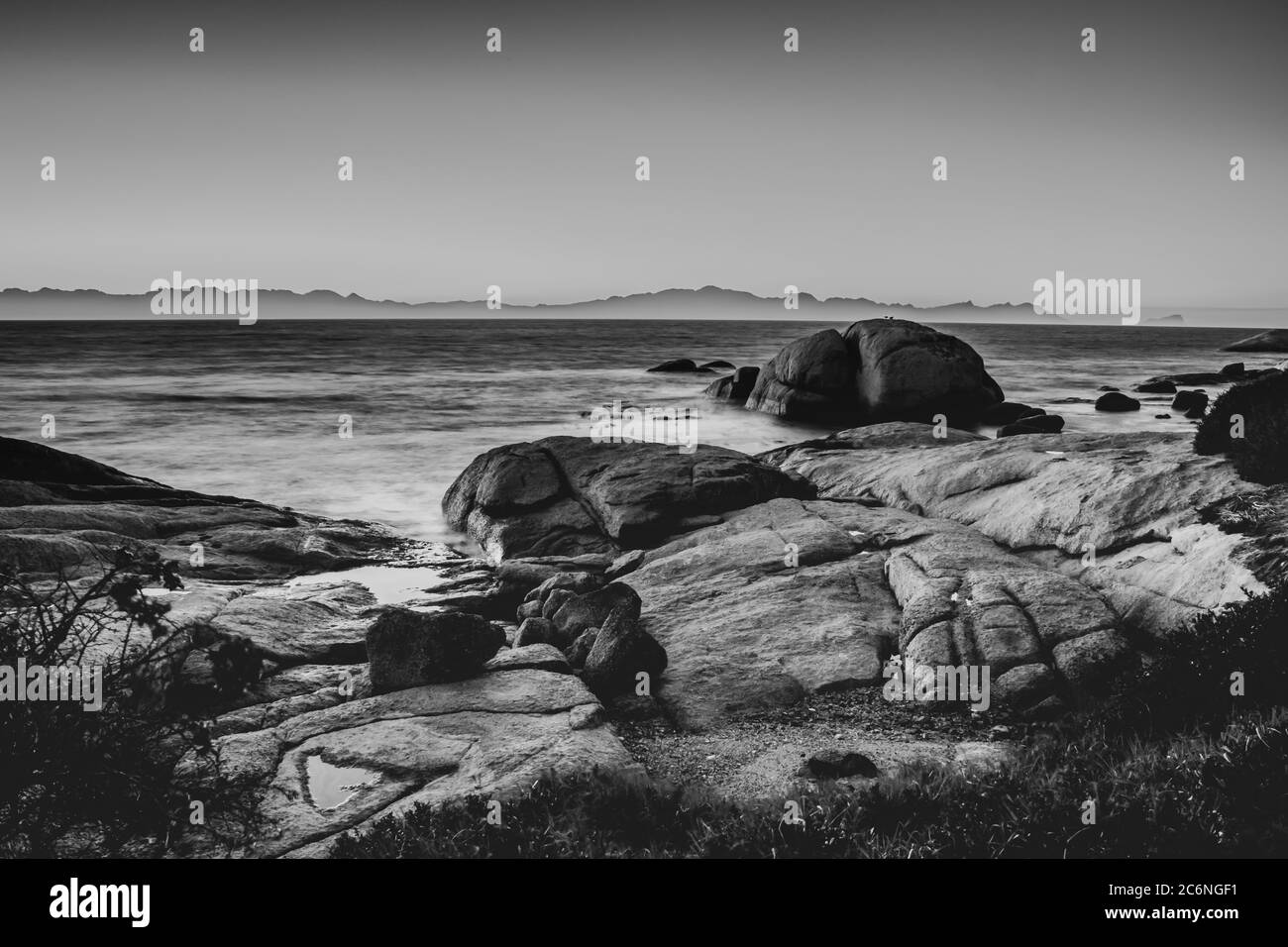 Vista di un'alba nuvolosa dalla spiaggia di Boulders con vista di False Bay, Simon's Town, Città del Capo, Sud Africa Foto Stock
