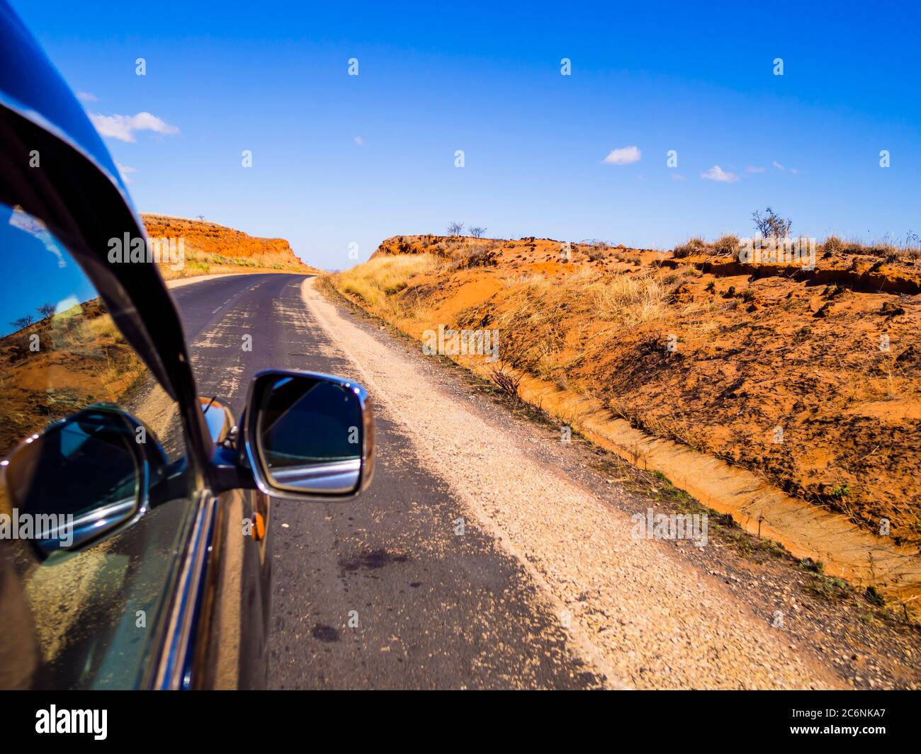 Guida un'auto sulla panoramica Route Nationale 7 (RN7) attraverso la savana degli altopiani del Madagascar Foto Stock