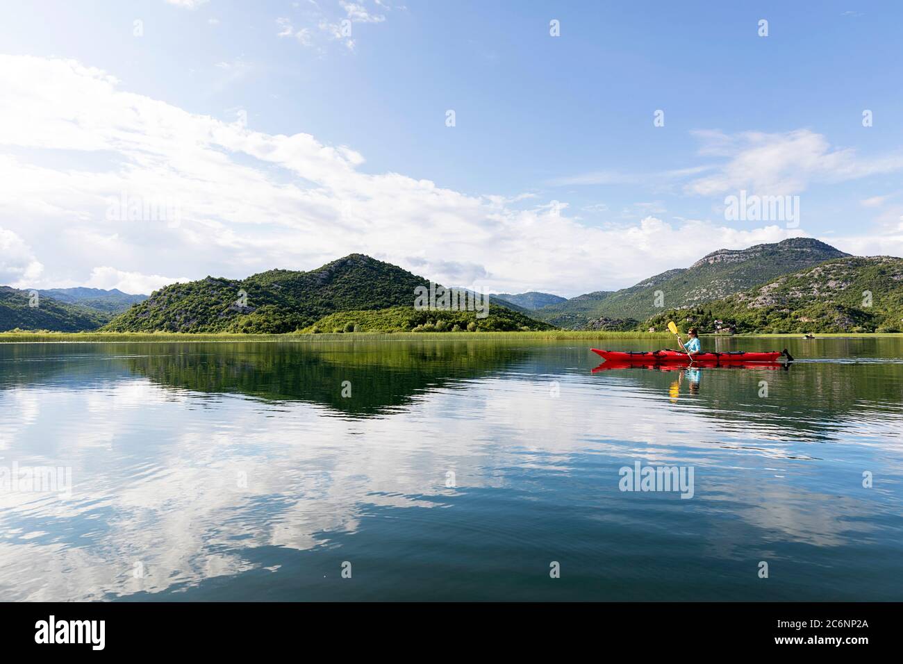 Donna in kayak rosso sul lago Skadar, Montenegro Foto Stock