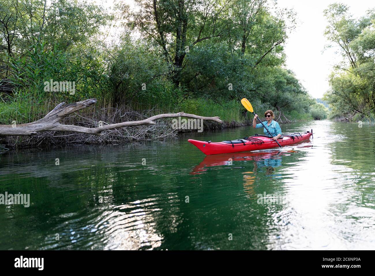 Donna in kayak rosso sul lago Skadar, Montenegro Foto Stock