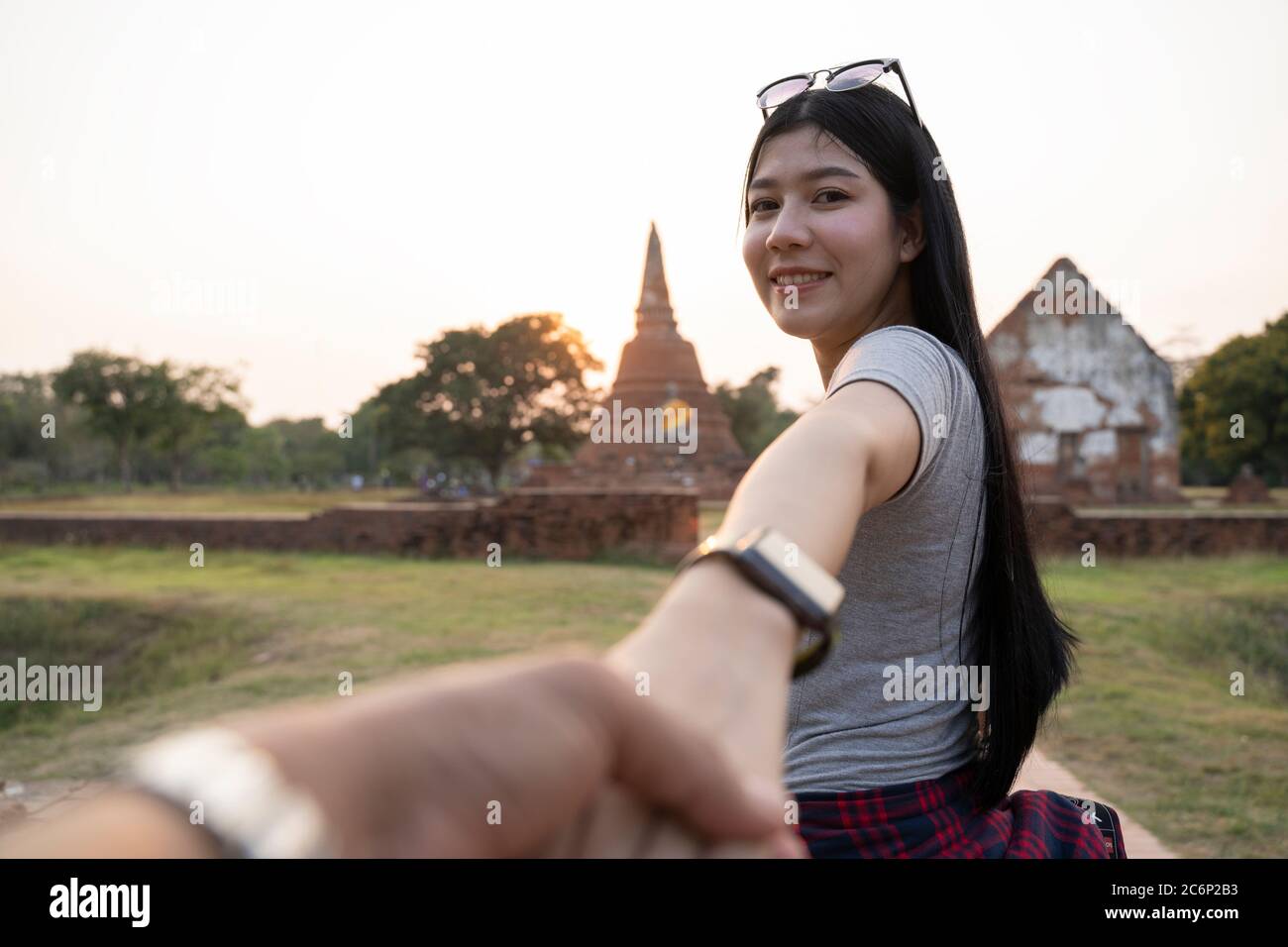 Seguimi al tempio, ayutthaya thailandia. Femmina turistico che conduce il ragazzo al tempio tailandese. Concetto di viaggio delle persone. Foto Stock