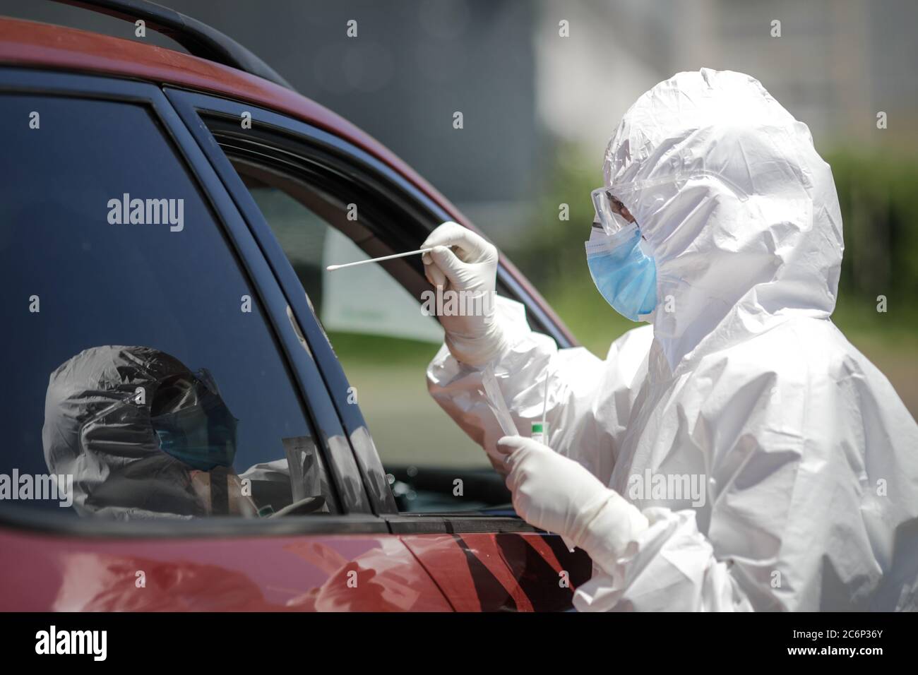 Bucarest / Romania - 11 luglio 2020: Un operatore sanitario utilizza un test CPR (bocca e tampone nasale) su una persona all'interno di un'auto per determinare la presenza o l'abuso Foto Stock