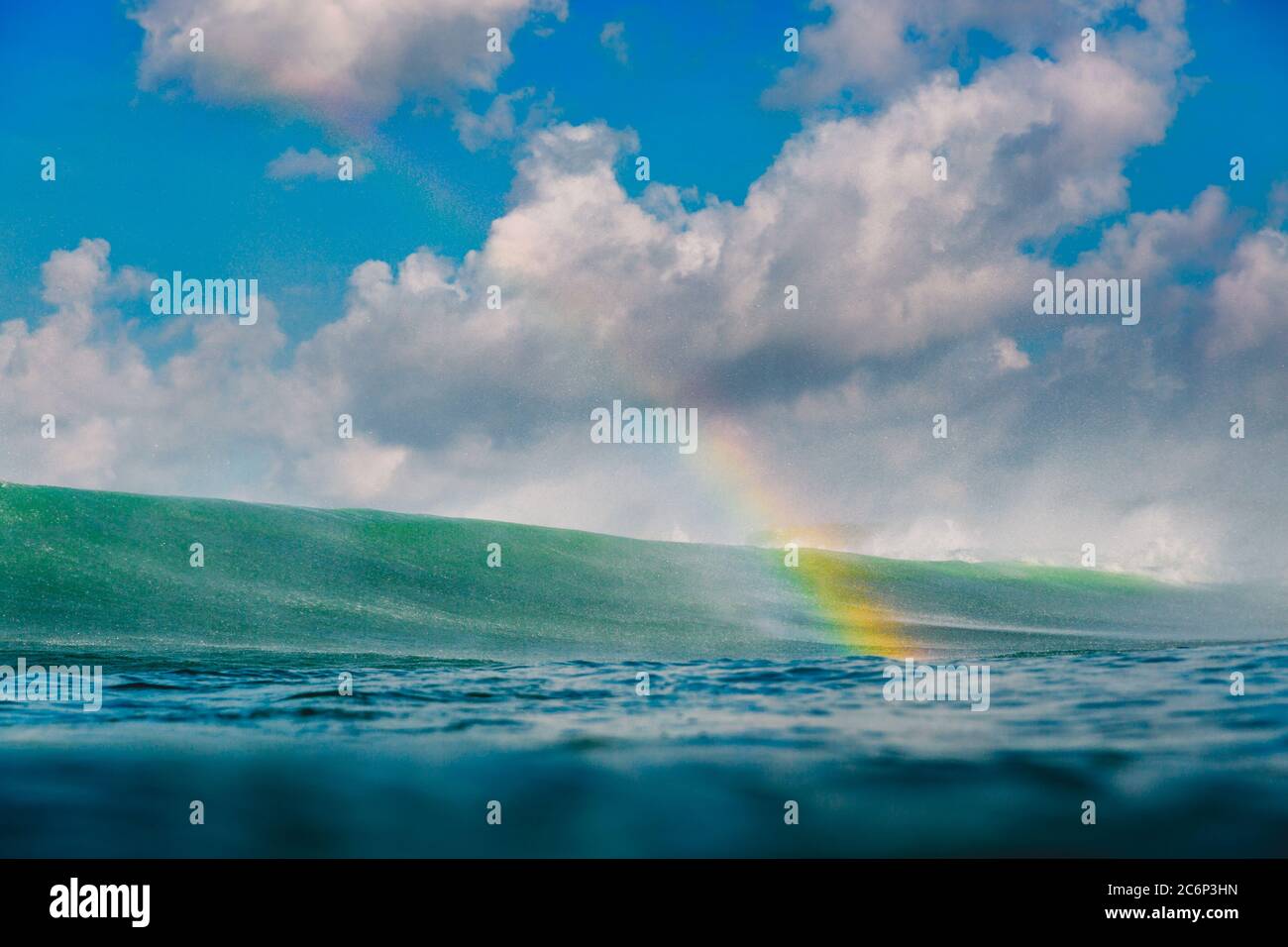 Arcobaleno dalla grande onda in oceano. Infrangere onde, gocce e arcobaleno Foto Stock