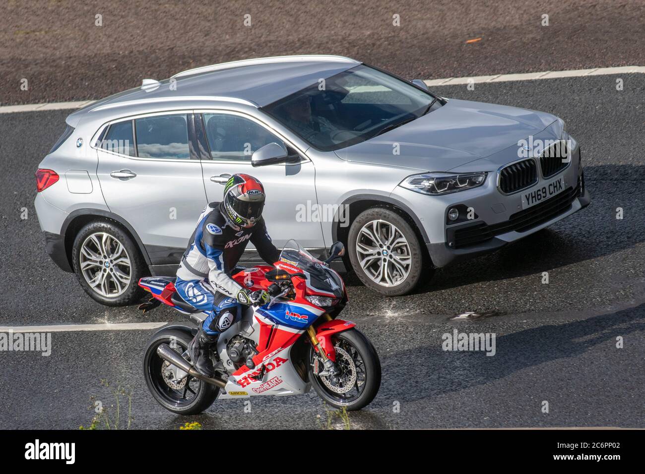 Rosso bianco blu Honda CBR team HRC Motorbike; due ruote di trasporto, moto, sorpasso BMW veicolo, strade, moto, moto motociclisti che automobilano a Chorley, Regno Unito Foto Stock