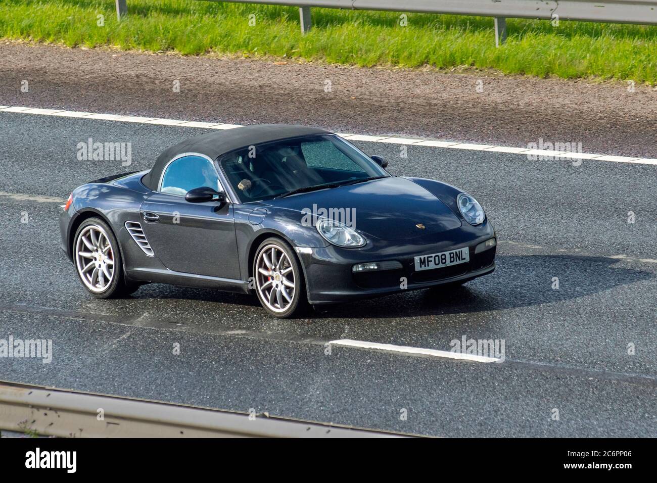 2008 Black Porsche Boxster S soft top; veicoli in movimento per il traffico veicolare, auto sportive che guidano veicoli su strade britanniche, motori, automobilismo sulla rete autostradale M6. Foto Stock