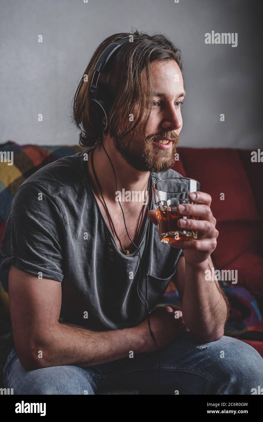 Uomo Barbuto in ascolto di musica con le cuffie Foto Stock